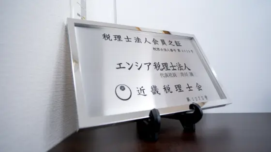 デスクの上に置かれた、銀色のフレームに入った税理士法人の会員証
